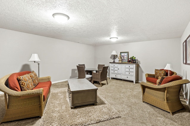 living area with baseboards, carpet, and a textured ceiling