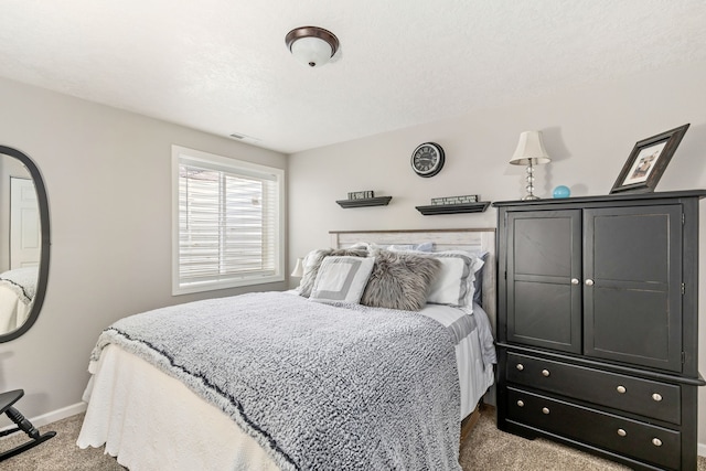 bedroom featuring visible vents, baseboards, carpet, and a textured ceiling