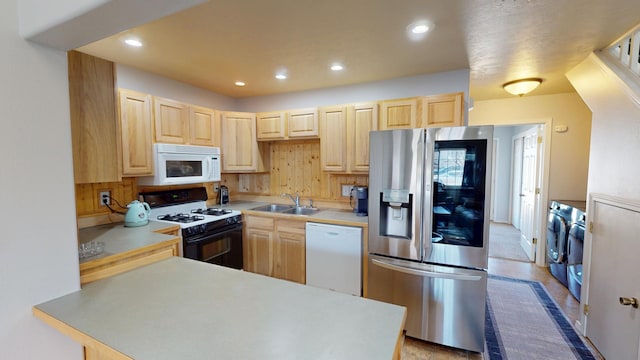 103 Alice Ave Unit B, Hamilton, MT 59840 - kitchen featuring white appliances, washer and dryer, light brown cabinetry, a peninsula, and light countertops