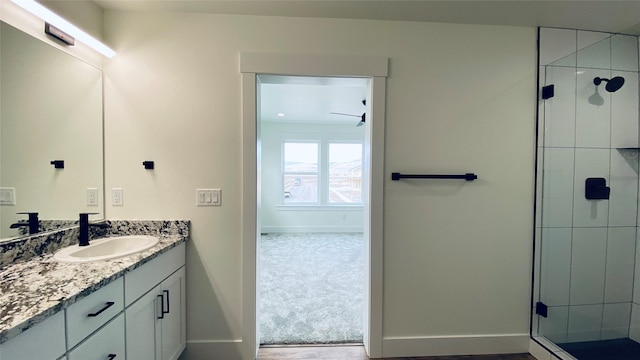 full bathroom with a shower stall, vanity, and baseboards