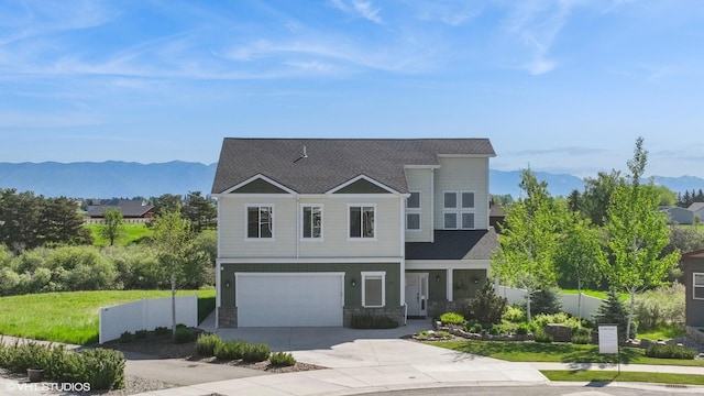 113 Mountain Vista Ct, Kalispell, MT 59901 - view of front of home featuring a mountain view, an attached garage, a shingled roof, driveway, and stone siding