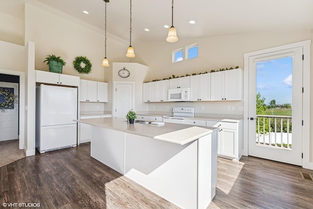113 Mountain Vista Ct, Kalispell, MT 59901 - kitchen with white appliances, high vaulted ceiling, white cabinets, light countertops, and a center island with sink