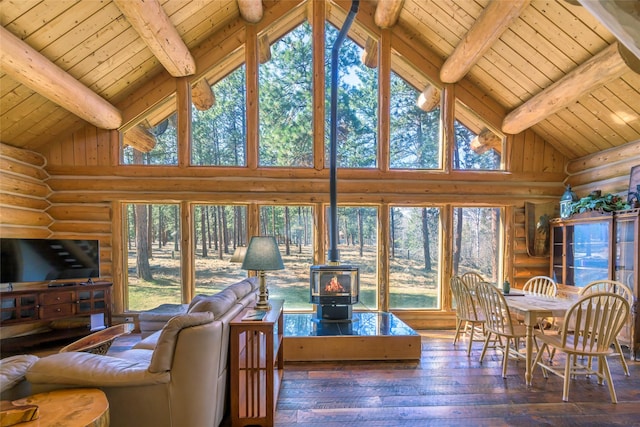 807 Pheasant Run, Hamilton, MT 59840 - living area with log walls, a wood stove, wooden ceiling with exposed beams, high vaulted ceiling, and hardwood / wood-style flooring