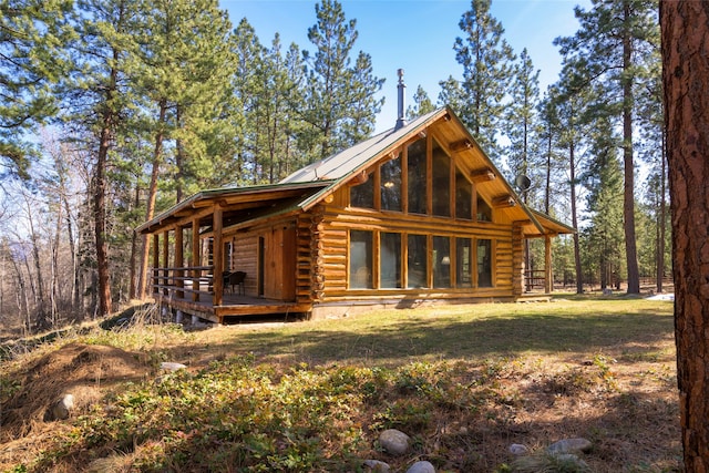 807 Pheasant Run, Hamilton, MT 59840 - view of front facade with log exterior, a wooden deck, and a front lawn