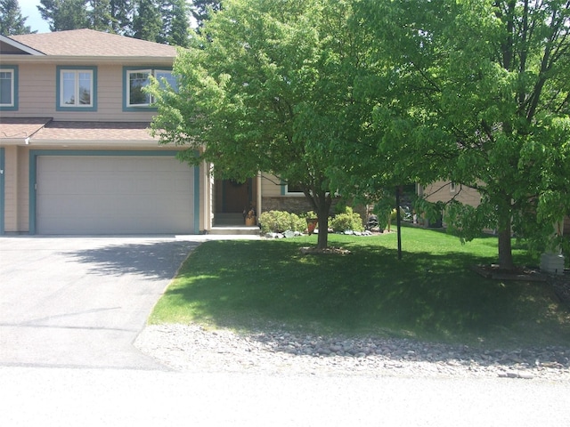 161 Oakmont Loop, Columbia Falls, MT 59912 - obstructed view of property with an attached garage, a front yard, asphalt driveway, and a shingled roof