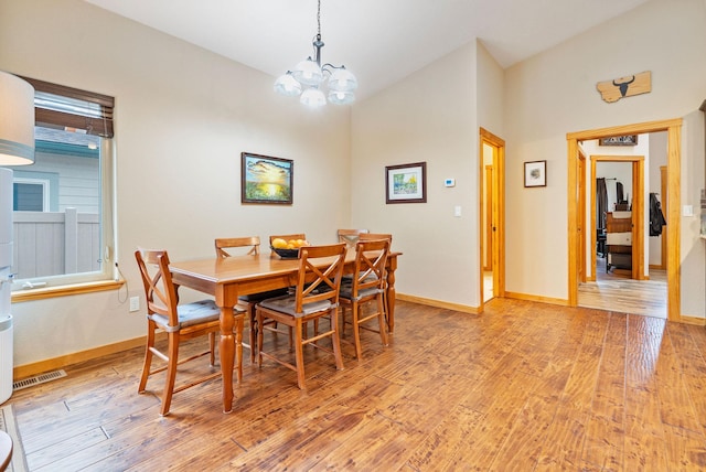 161 Oakmont Loop, Columbia Falls, MT 59912 - dining space featuring light wood-style flooring, lofted ceiling, a chandelier, and baseboards