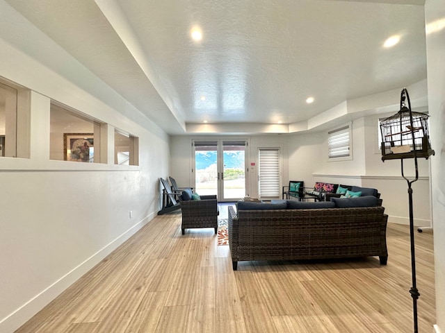 113 Mission Bay Dr, Polson, MT 59860 - living room featuring baseboards, light wood finished floors, recessed lighting, and a raised ceiling