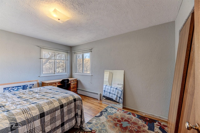 4212 W US Highway 12, Helena, MT 59601 - bedroom with a baseboard heating unit, a textured ceiling, light wood-type flooring, and a textured wall