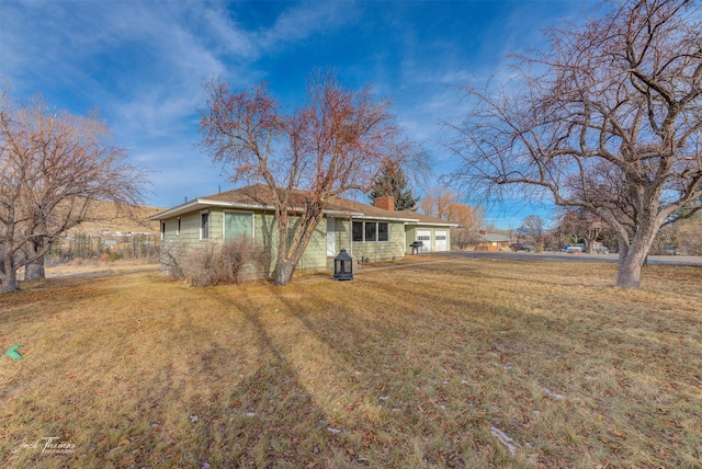 4212 W US Highway 12, Helena, MT 59601 - view of front of property featuring a chimney, a front yard, and a garage