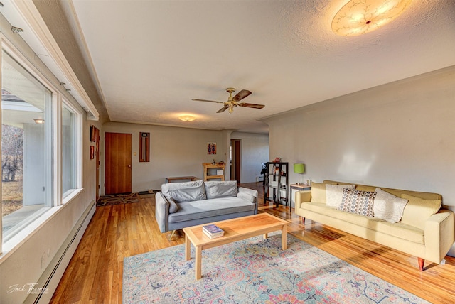 4212 W US Highway 12, Helena, MT 59601 - living area featuring a baseboard radiator, wood finished floors, and a ceiling fan