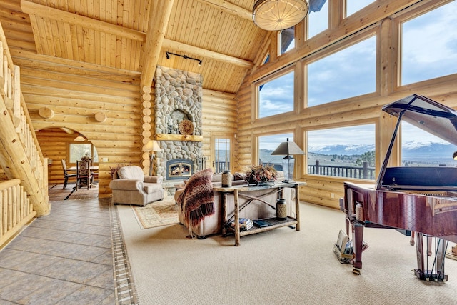 1130 Hegson Dr, Stevensville, MT 59870 - living room featuring log walls, wood ceiling with exposed beams, high vaulted ceiling, a stone fireplace, and plenty of natural light