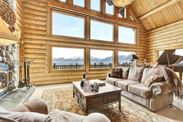1130 Hegson Dr, Stevensville, MT 59870 - carpeted living area with high vaulted ceiling, log walls, a stone fireplace, wooden ceiling with exposed beams, and a mountain view