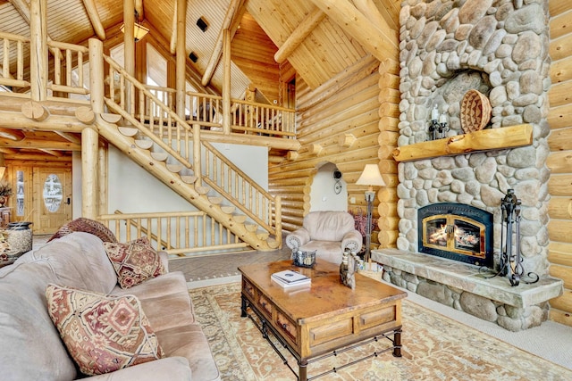 1130 Hegson Dr, Stevensville, MT 59870 - living area featuring rustic walls, high vaulted ceiling, wooden ceiling with exposed beams, a stone fireplace, and stairway