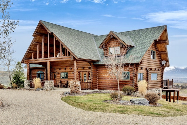 1130 Hegson Dr, Stevensville, MT 59870 - log-style house featuring log exterior, roof with shingles, and covered porch