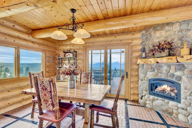 1130 Hegson Dr, Stevensville, MT 59870 - dining room with log walls, wooden ceiling with exposed beams, plenty of natural light, and a fireplace