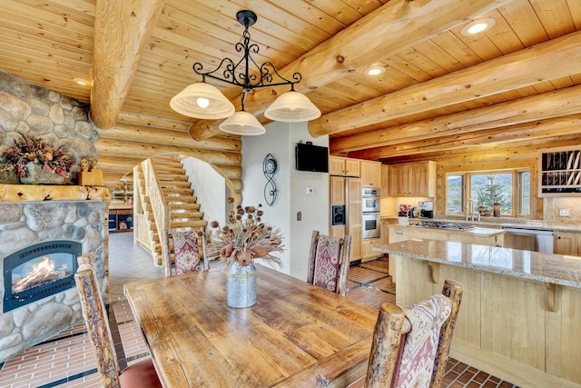 1130 Hegson Dr, Stevensville, MT 59870 - dining area featuring log walls, wooden ceiling with exposed beams, recessed lighting, and a fireplace