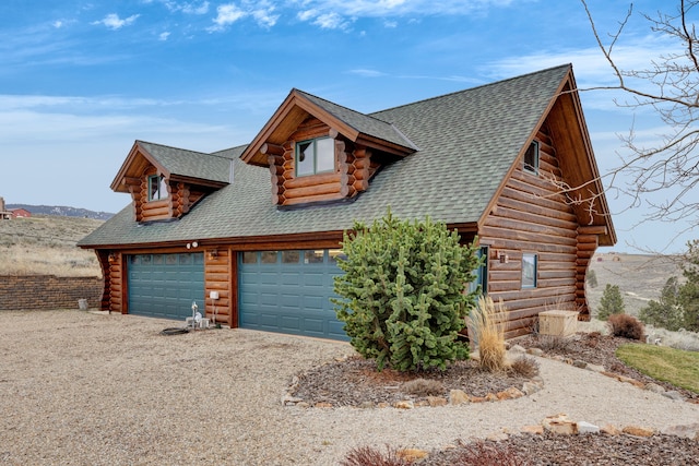 1130 Hegson Dr, Stevensville, MT 59870 - cabin featuring log exterior, roof with shingles, and a garage