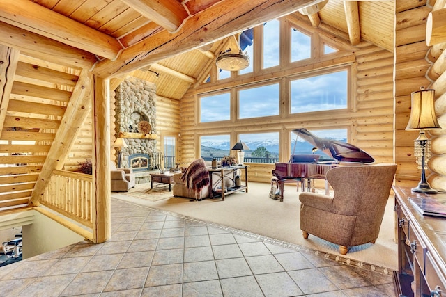 1130 Hegson Dr, Stevensville, MT 59870 - carpeted living room with rustic walls, wooden ceiling with exposed beams, high vaulted ceiling, tile patterned flooring, and a fireplace