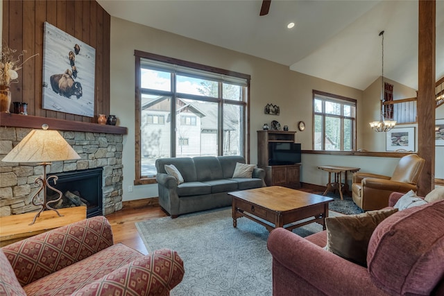 1 Rock Creek Ct, Whitefish, MT 59937 - living area featuring vaulted ceiling, wood finished floors, a fireplace, a chandelier, and a ceiling fan