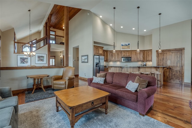 1 Rock Creek Ct, Whitefish, MT 59937 - living room with high vaulted ceiling, light wood-style flooring, a chandelier, and baseboards