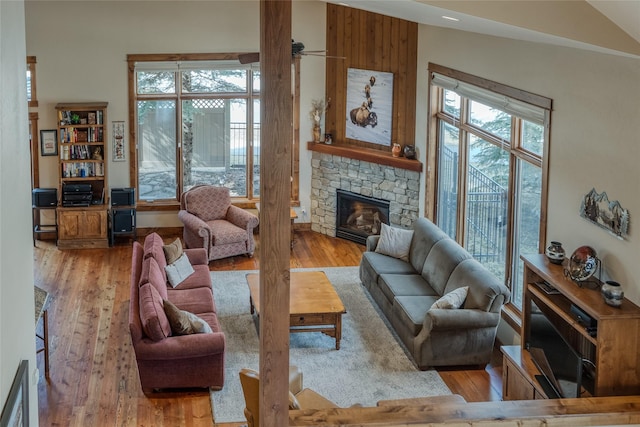 1 Rock Creek Ct, Whitefish, MT 59937 - living area featuring wood finished floors, a stone fireplace, and a ceiling fan