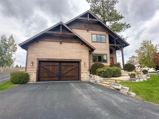 1 Rock Creek Ct, Whitefish, MT 59937 - view of front of home with driveway, stone siding, and a garage
