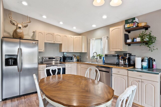 253 Aero Ln, Bigfork, MT 59911 - kitchen featuring appliances with stainless steel finishes, light brown cabinets, light wood-type flooring, recessed lighting, and vaulted ceiling