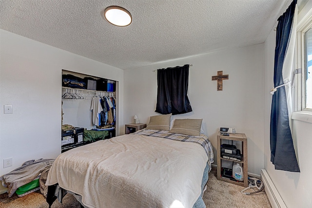 bedroom with carpet flooring, a closet, a baseboard heating unit, and a textured ceiling