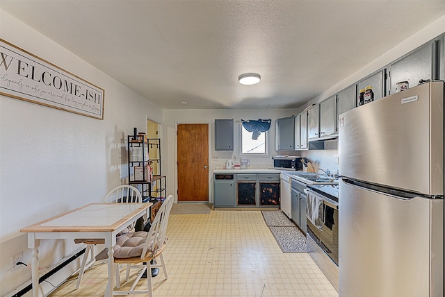 1312 Cole Ave, Helena, MT 59601 - kitchen with stainless steel appliances, gray cabinets, light flooring, light countertops, and a textured ceiling