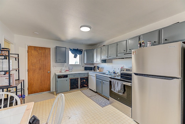 1312 Cole Ave, Helena, MT 59601 - kitchen with stainless steel appliances, gray cabinetry, light flooring, and light countertops
