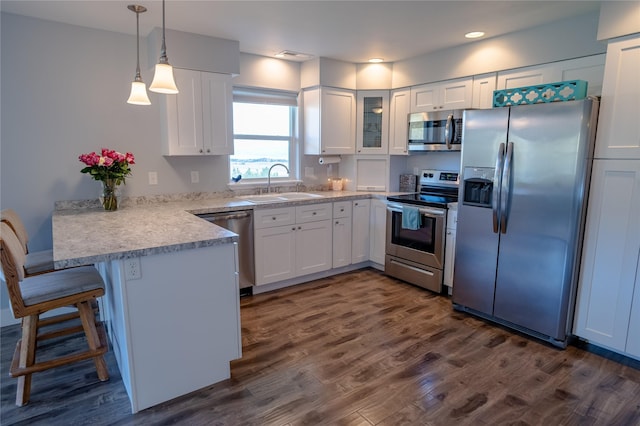 9 Ridge View Cir, Montana City, MT 59634 - kitchen with appliances with stainless steel finishes, a peninsula, white cabinets, dark wood-style floors, and glass insert cabinets
