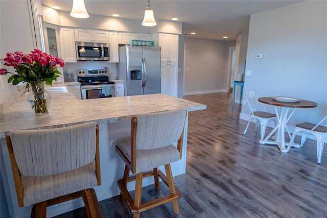 9 Ridge View Cir, Montana City, MT 59634 - kitchen with appliances with stainless steel finishes, a peninsula, dark wood-style floors, white cabinets, and recessed lighting