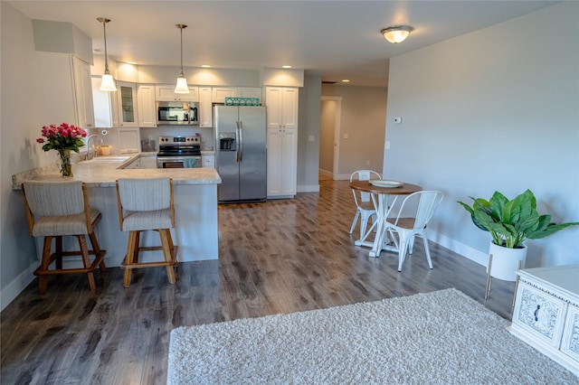9 Ridge View Cir, Montana City, MT 59634 - kitchen featuring stainless steel appliances, glass insert cabinets, white cabinetry, a peninsula, and dark wood-type flooring