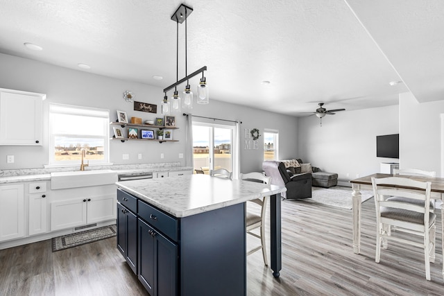 2009 Meriwether Ct, Great Falls, MT 59405 - kitchen featuring a kitchen bar, white cabinetry, a sink, and a ceiling fan