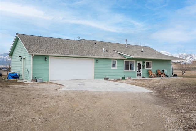 552 Pat Ln, Stevensville, MT 59870 - rear view of house featuring concrete driveway and roof with shingles