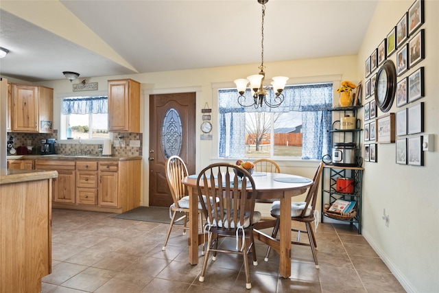 552 Pat Ln, Stevensville, MT 59870 - dining space with baseboards, lofted ceiling, light tile patterned flooring, and a notable chandelier