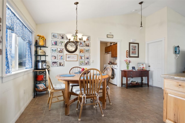 552 Pat Ln, Stevensville, MT 59870 - dining space with baseboards, independent washer and dryer, vaulted ceiling, and an inviting chandelier