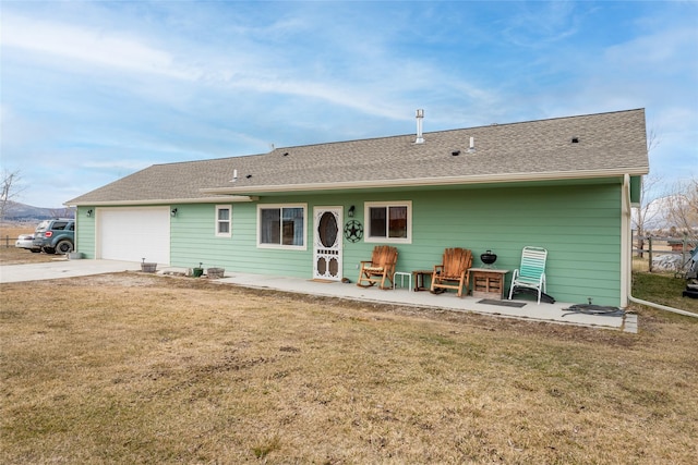 552 Pat Ln, Stevensville, MT 59870 - back of house with driveway, a shingled roof, a garage, and a yard
