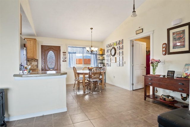 552 Pat Ln, Stevensville, MT 59870 - kitchen with tile patterned floors, pendant lighting, lofted ceiling, decorative backsplash, and an inviting chandelier