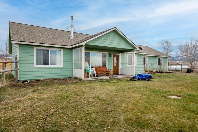 552 Pat Ln, Stevensville, MT 59870 - rear view of property featuring fence, roof with shingles, a yard, and a patio area