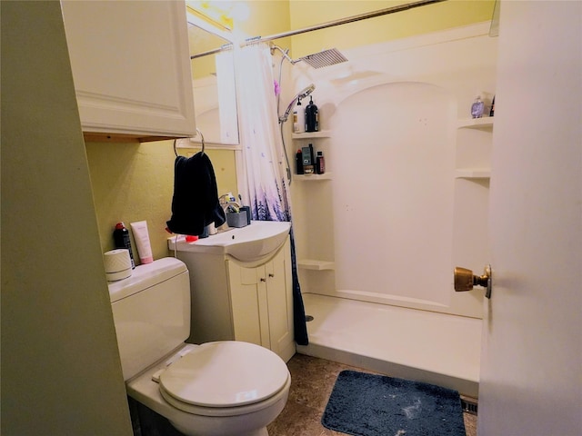 bathroom with a stall shower, toilet, and vanity