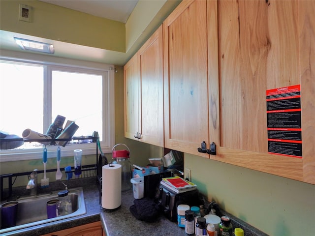 kitchen featuring a sink, dark countertops, visible vents, and light brown cabinetry