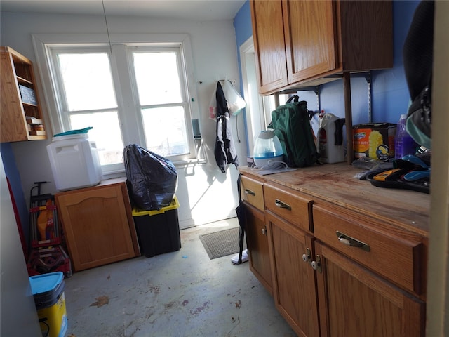 interior space featuring concrete flooring, visible vents, light countertops, and brown cabinets