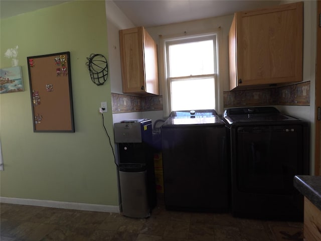 washroom with cabinet space, washing machine and dryer, and baseboards