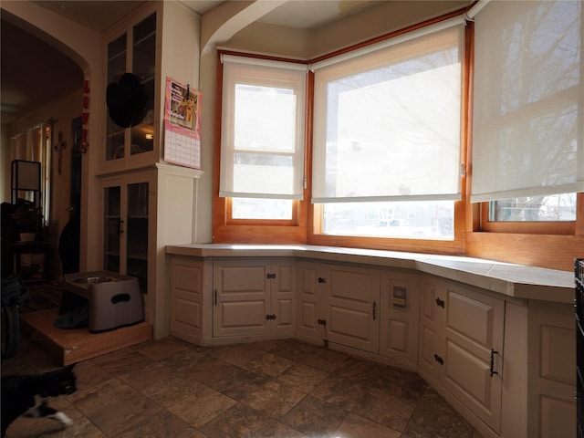 kitchen featuring light countertops, arched walkways, and stone finish flooring