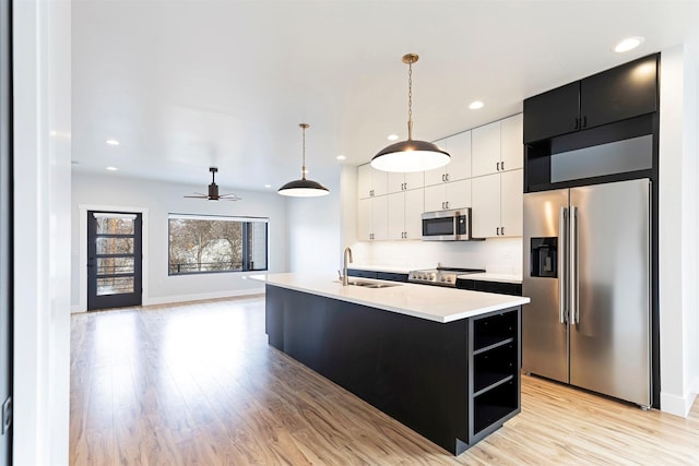 2212 S 12th St W, Missoula, MT 59801 - kitchen with white cabinets, light wood-style flooring, light countertops, stainless steel appliances, and a sink