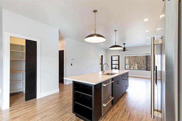 2212 S 12th St W, Missoula, MT 59801 - kitchen featuring stainless steel fridge, a kitchen island with sink, a sink, light wood-type flooring, and a warming drawer
