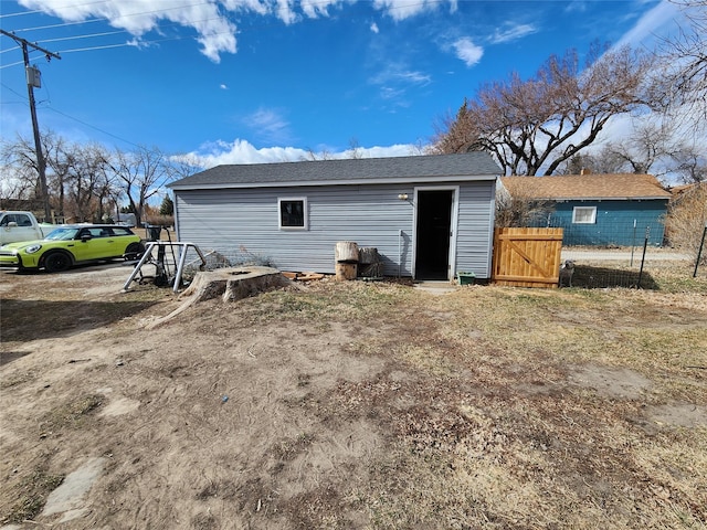 exterior space with fence and roof with shingles
