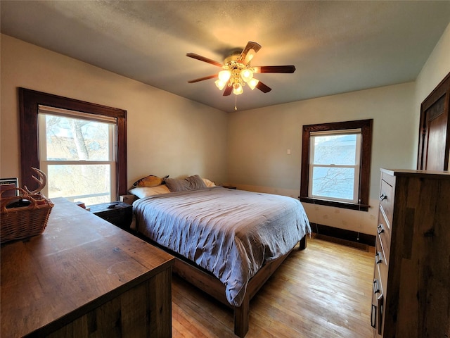 bedroom featuring baseboards, ceiling fan, and light wood-style floors