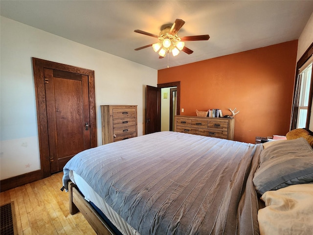 bedroom with baseboards, ceiling fan, and light wood finished floors